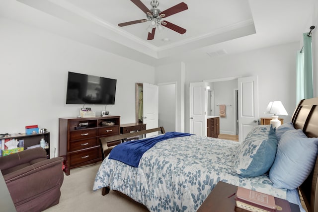 bedroom with visible vents, ornamental molding, light colored carpet, a tray ceiling, and a ceiling fan