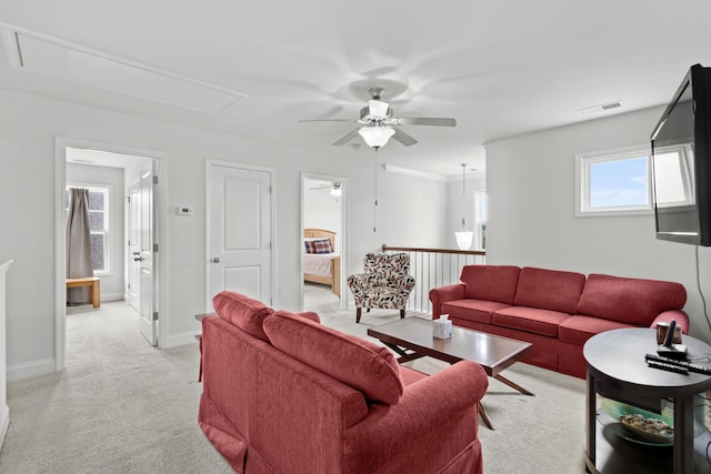 living room with ceiling fan, attic access, light colored carpet, visible vents, and baseboards