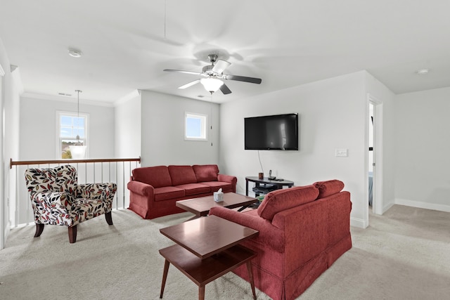 living room with a ceiling fan, baseboards, light carpet, and ornamental molding
