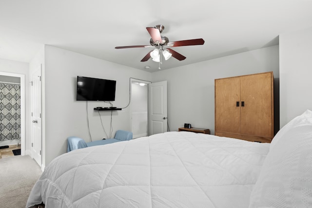 carpeted bedroom with ceiling fan and ensuite bath