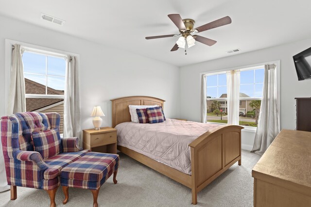 bedroom with visible vents, light carpet, and multiple windows