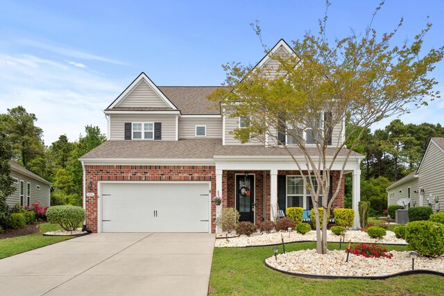 craftsman-style home featuring a garage, a front yard, roof with shingles, brick siding, and driveway