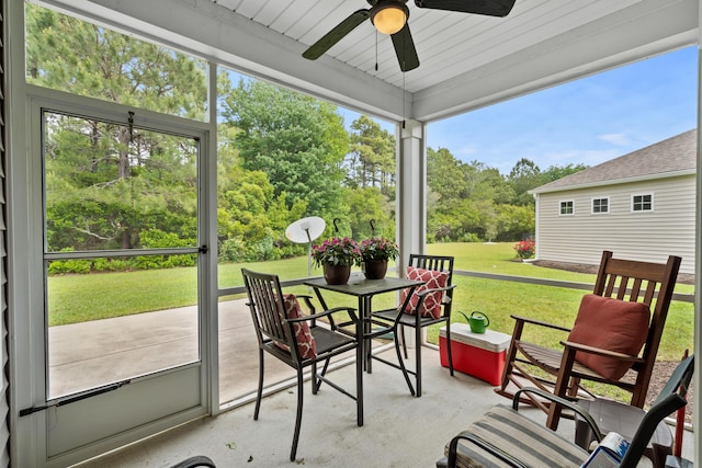 sunroom / solarium featuring plenty of natural light, outdoor dining space, and ceiling fan