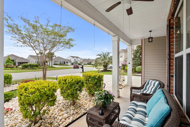 view of patio / terrace featuring covered porch, ceiling fan, and a residential view