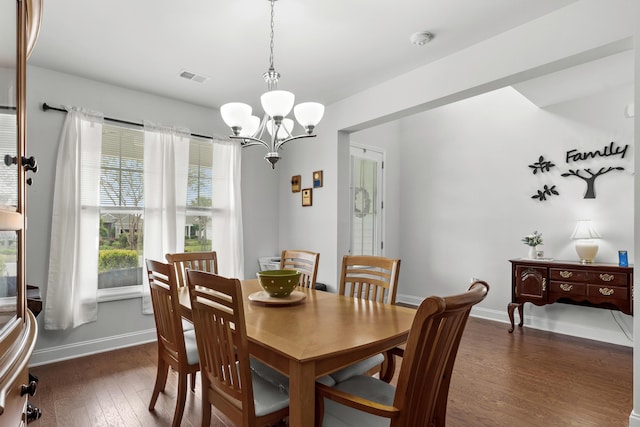 dining space with an inviting chandelier, baseboards, dark wood-type flooring, and visible vents