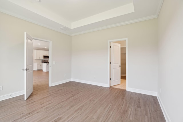 spare room featuring ornamental molding and light wood-type flooring