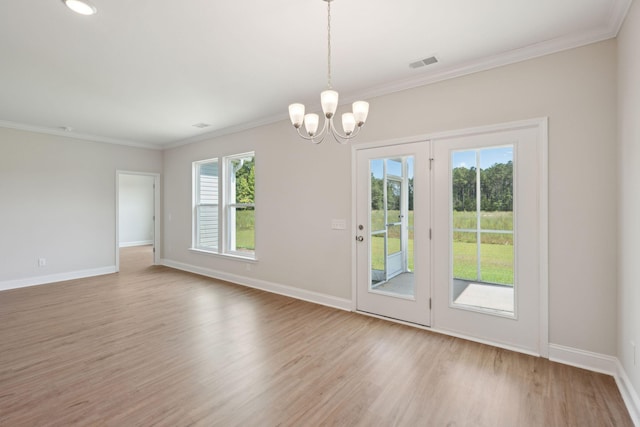 interior space with baseboards, visible vents, wood finished floors, and ornamental molding