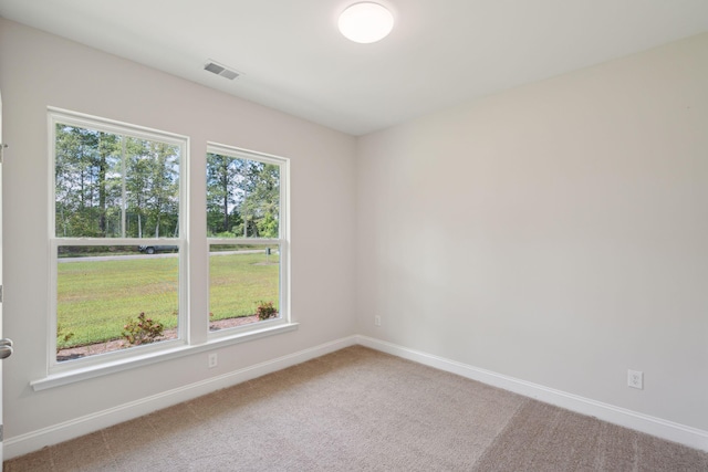 carpeted empty room with visible vents and baseboards