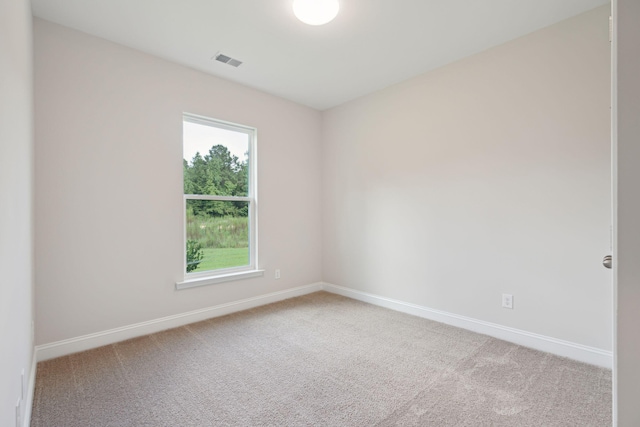 unfurnished room featuring carpet, visible vents, and baseboards