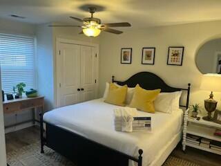 bedroom with dark hardwood / wood-style floors, a closet, and ceiling fan