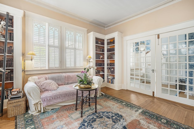 living area with french doors, crown molding, and wood finished floors