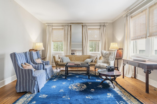 living area with ornamental molding, baseboards, and wood finished floors