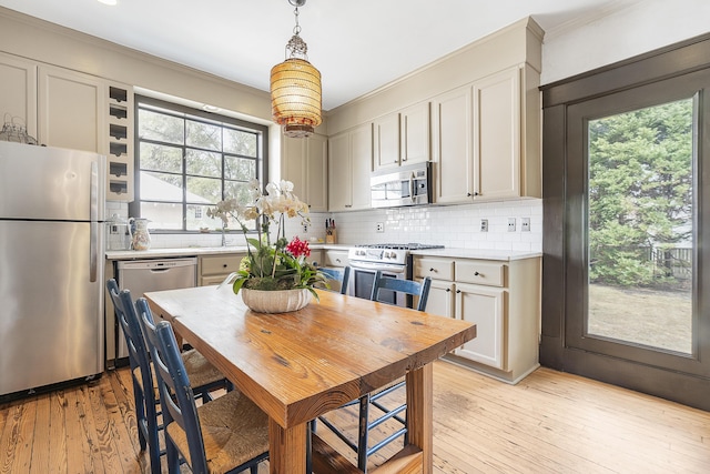 kitchen with backsplash, light wood-style flooring, stainless steel appliances, and light countertops