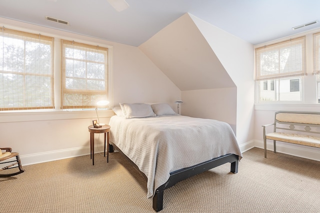 carpeted bedroom featuring visible vents, vaulted ceiling, and baseboards