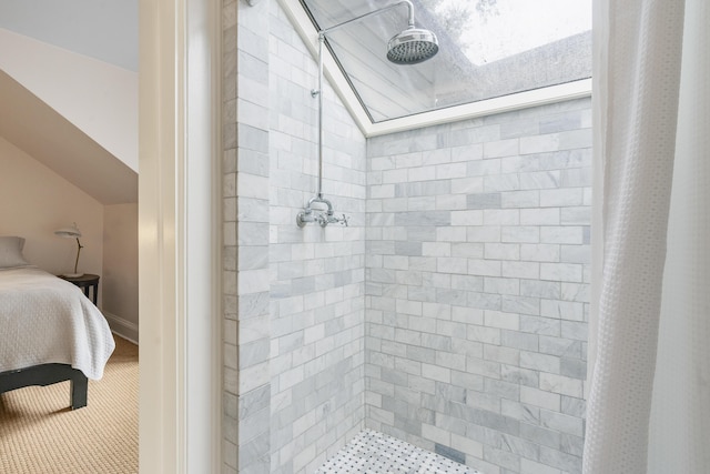 bathroom featuring lofted ceiling, tiled shower, and ensuite bathroom