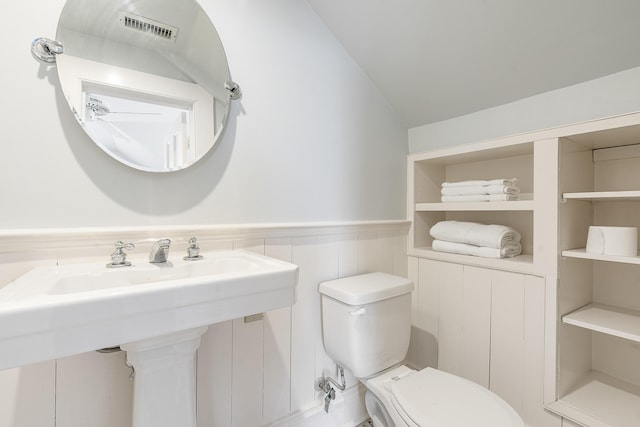 bathroom featuring a wainscoted wall, a sink, visible vents, and toilet