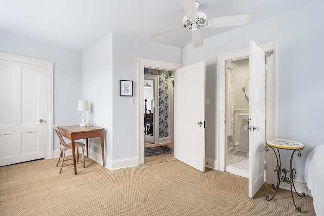 bedroom with a ceiling fan, light carpet, connected bathroom, and baseboards