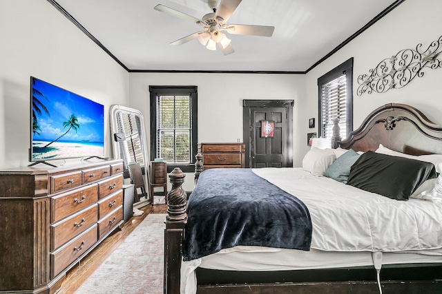 bedroom featuring ceiling fan, crown molding, and wood-type flooring