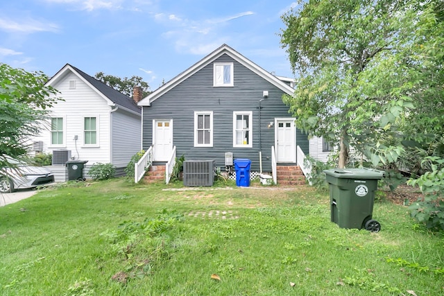 back of house with cooling unit and a yard