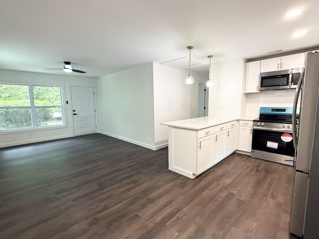 208 Orange St, Walterboro, SC 29488 - kitchen featuring stainless steel appliances, a peninsula, dark wood-type flooring, open floor plan, and white cabinets