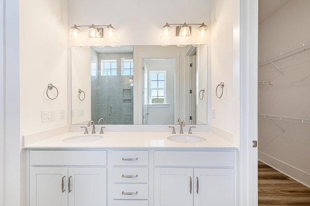 bathroom featuring hardwood / wood-style flooring, vanity, and an enclosed shower