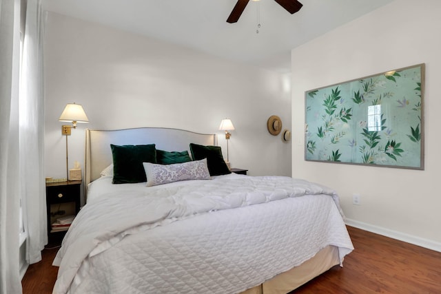 bedroom featuring a ceiling fan, baseboards, and wood finished floors