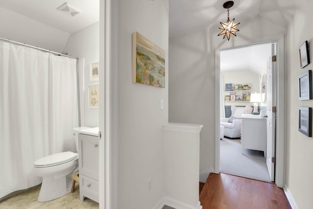 bathroom featuring lofted ceiling, visible vents, toilet, and wood finished floors