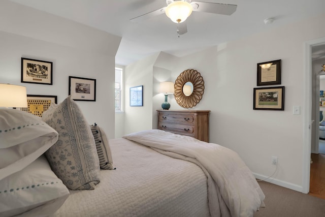 carpeted bedroom with ceiling fan and baseboards