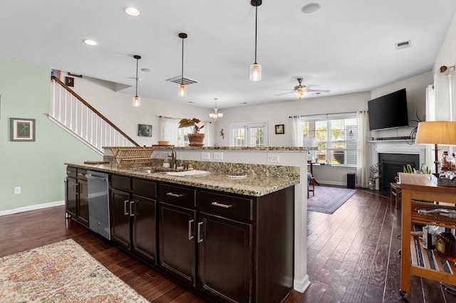 1821 Towne St, Johns Island, SC 29455 - kitchen featuring stainless steel dishwasher, a fireplace, a ceiling fan, dark wood-type flooring, and light stone counters