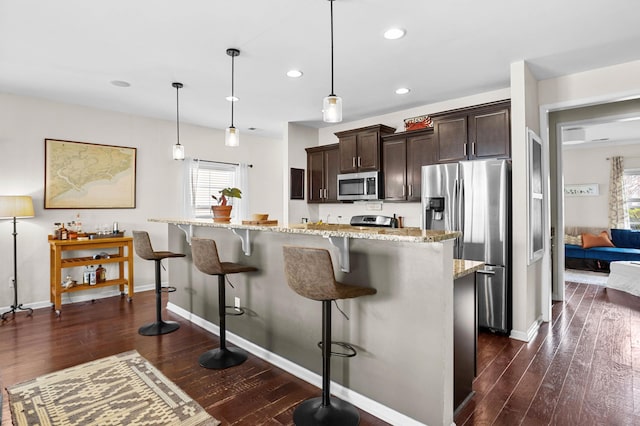 1821 Towne St, Johns Island, SC 29455 - kitchen with appliances with stainless steel finishes, healthy amount of natural light, dark brown cabinetry, a breakfast bar area, and recessed lighting