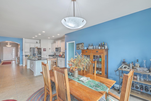 dining space featuring sink and light tile patterned flooring