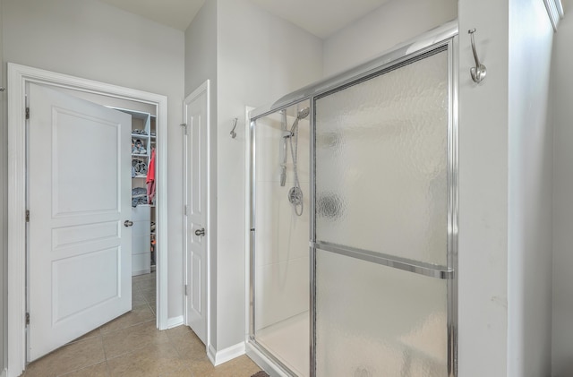 bathroom featuring a shower with shower door and tile patterned flooring