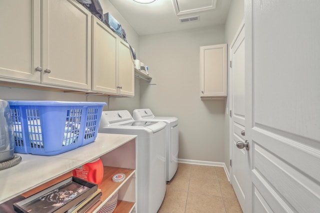 laundry area featuring cabinets, light tile patterned flooring, and washing machine and clothes dryer