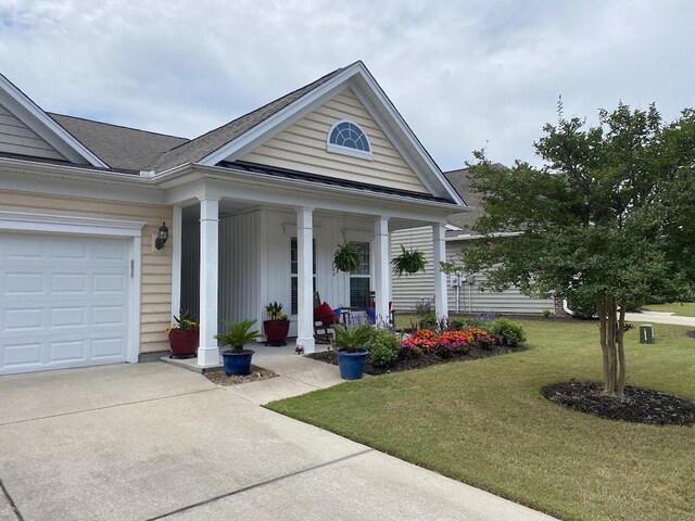 view of front of home featuring a garage, covered porch, and a front yard