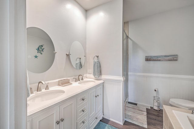 bathroom featuring toilet, an enclosed shower, vanity, and hardwood / wood-style flooring