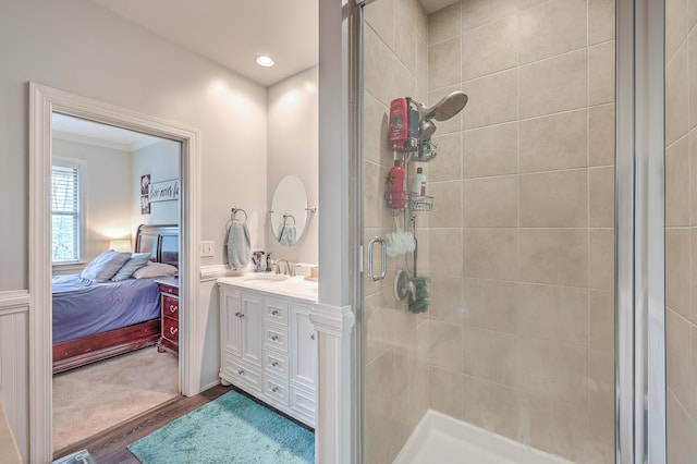 bathroom with crown molding, hardwood / wood-style floors, an enclosed shower, and vanity