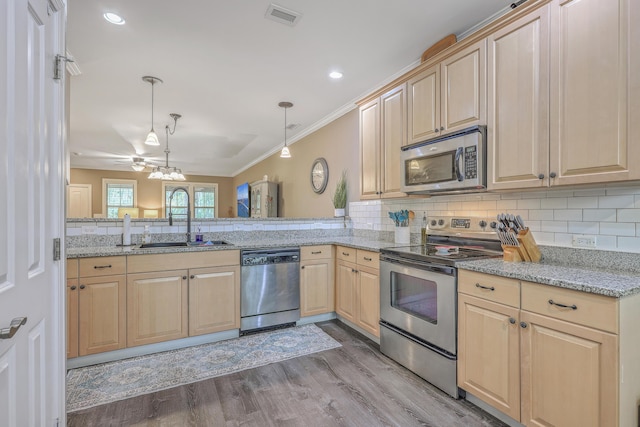 kitchen with kitchen peninsula, decorative light fixtures, stainless steel appliances, ceiling fan, and sink