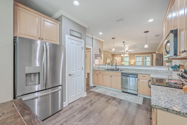 kitchen with kitchen peninsula, pendant lighting, appliances with stainless steel finishes, ceiling fan, and sink