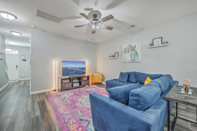 living room with ceiling fan and dark wood-type flooring