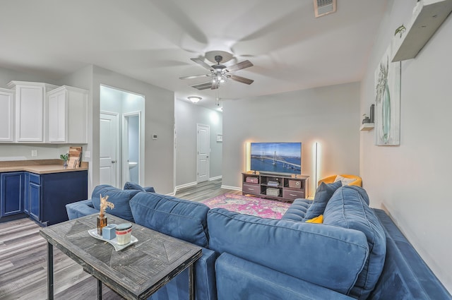 living room featuring light hardwood / wood-style flooring and ceiling fan