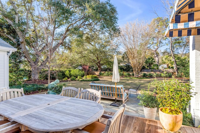 wooden deck with fence, outdoor dining area, and a patio