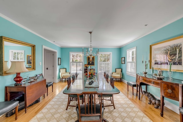 dining area with an inviting chandelier, plenty of natural light, and ornamental molding