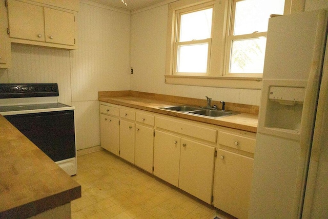 kitchen featuring stove, white fridge with ice dispenser, and sink