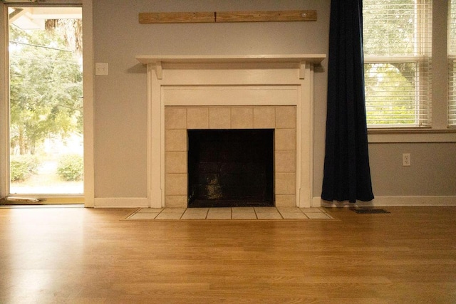 details featuring hardwood / wood-style flooring and a tiled fireplace