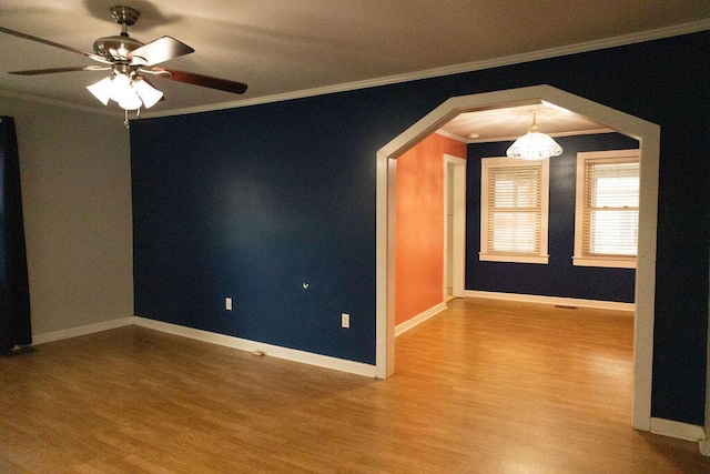 unfurnished room featuring hardwood / wood-style floors, ceiling fan with notable chandelier, and crown molding