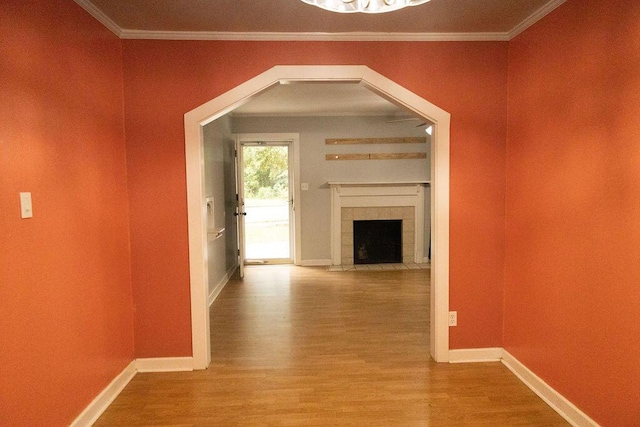 hallway with light hardwood / wood-style flooring and ornamental molding