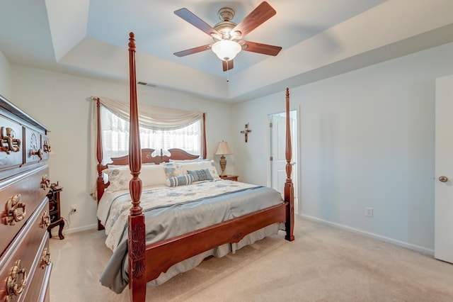 carpeted bedroom featuring a raised ceiling and ceiling fan