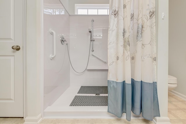 bathroom featuring a shower with curtain, tile patterned floors, and toilet