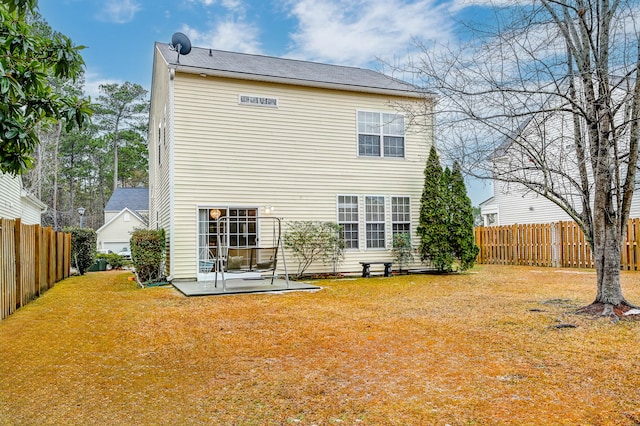 back of house with a yard and a patio