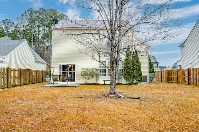 back of property with a yard and a patio area